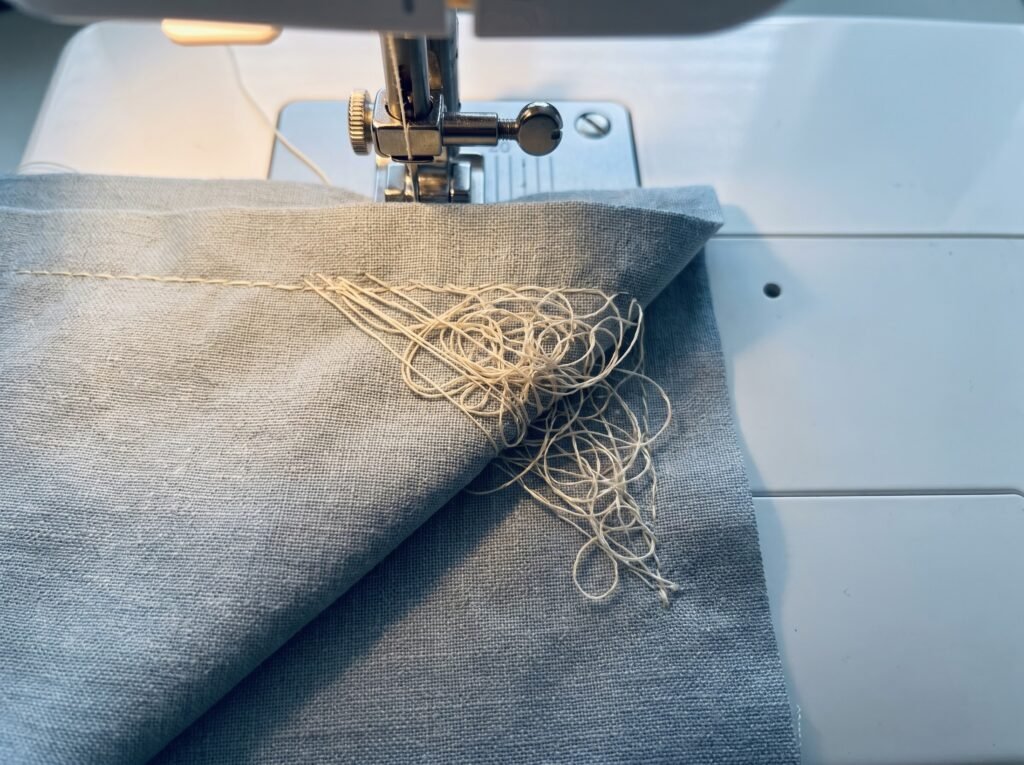 bird's nest thread bunching on fabric caused by a threading error, visible at the start of a seam