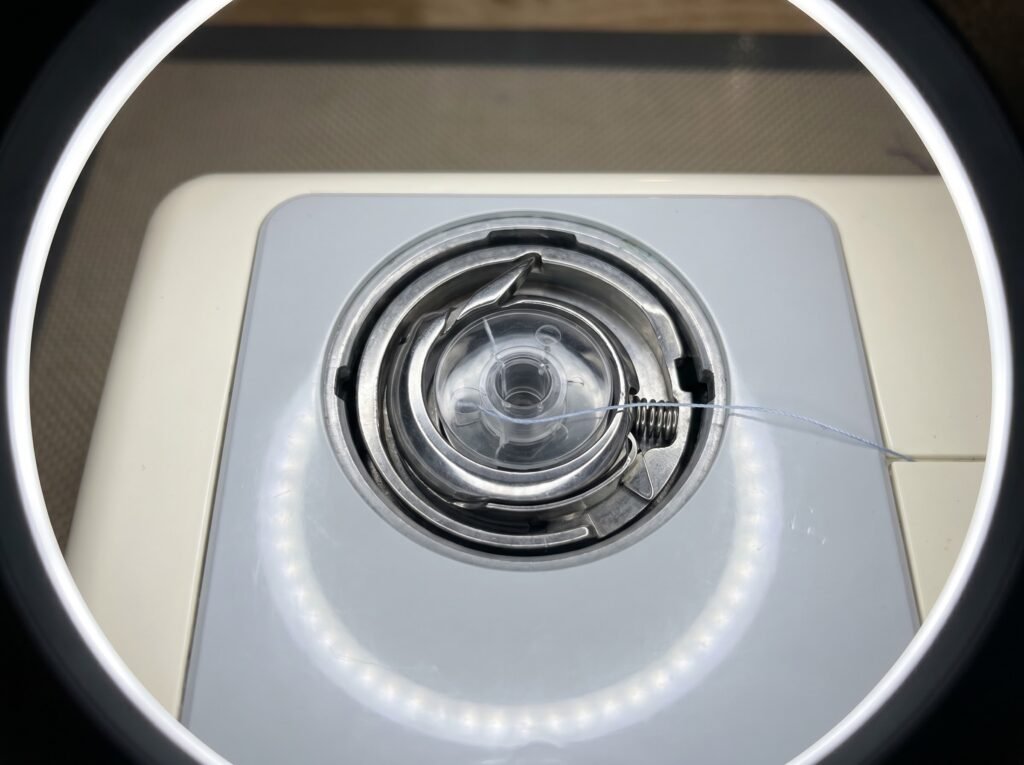 Drop-in bobbin and rotary hook assembly exposed inside a home sewing machine